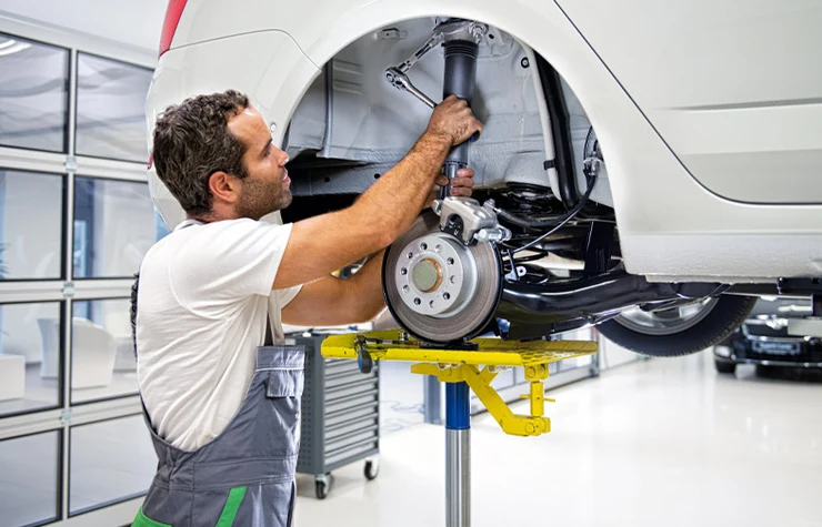 Mechanik vykonáva opravu tlmičov kolesa.
