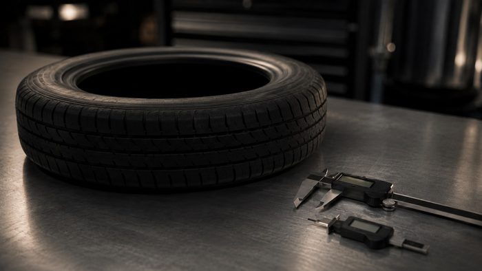 Pneumatika na pracovnom stole vedľa posuvného meradla a hĺbkomeru